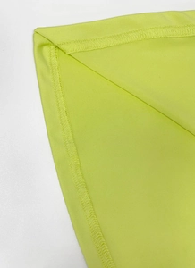 Close-up of lime green stretch fabric showing high-quality overlock stitching detail