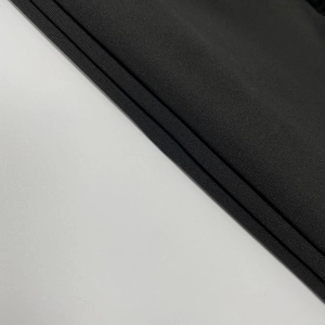 Detail shot of the black knit fabric texture and premium elastic material on a dress