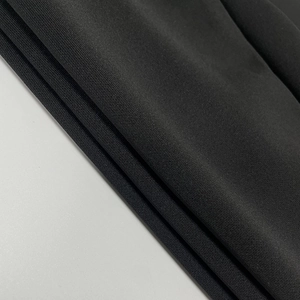 Vue macro de couches de tissu en maille noire montrant une texture fine et un tissage uniforme