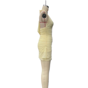 Detail of light yellow halter bodycon dress featuring side ruching and semi-sheer fabric