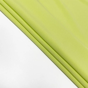 Detail shot of the lime green ribbed knit fabric showing soft texture and premium drape
