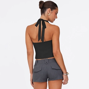 Detail eines schwarzen Neckholder-Tops mit großer Rückenschleife und grauen Cargo-Shorts