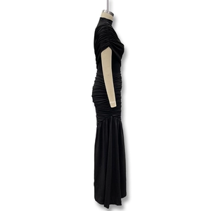Close-up of black ruched sleeveless dress featuring detailed pleated fabric and slim fit