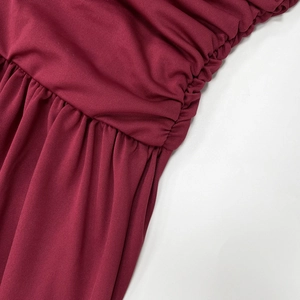 Gros plan détaillé du tissu en maille rouge foncé avec côtes verticales et plis froissés