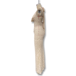 Dettaglio del pizzo traforato beige su un abito lungo con scollo a V e schiena scoperta