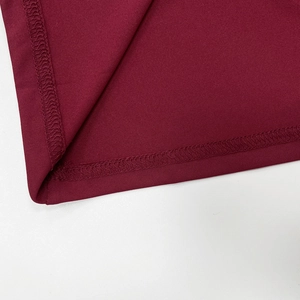 Détail de la couture à double aiguille sur l'ourlet d'une robe en tricot bordeaux