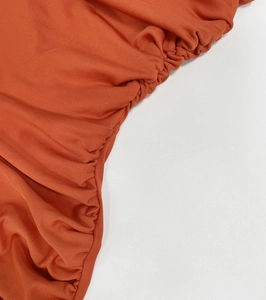 Detailed close-up showing the ruched fabric texture of the burnt orange summer dress