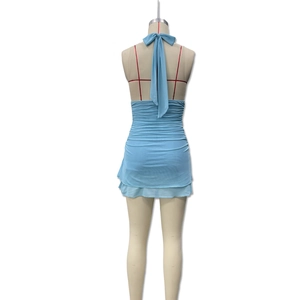 Detail of light blue halter dress featuring a large bow tie back and tiered ruffle hem