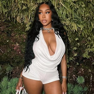 Detail of white satin halter neck romper featuring a deep V-neckline and open back design