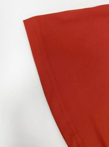 Detail view of brick red dress with high-density knit fabric and double-needle stitching