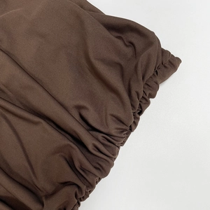 Détail macro du tricot côtelé élastique marron foncé avec finition froncée précise