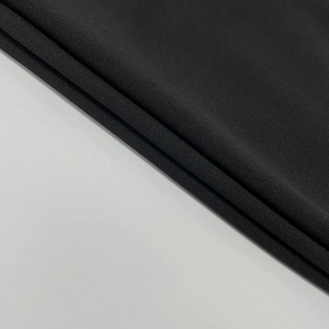 Gros plan sur la texture du textile tricoté noir et les détails tissés de la combinaison