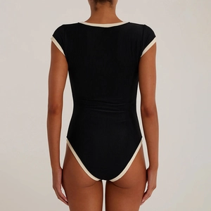 Détail de la texture en maille côtelée au dos d'un body noir avec bordure beige