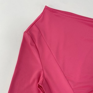 Détail de la couture d'épaule et texture fine sur le tissu rose de la combinaison chic