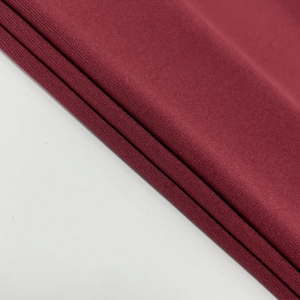 Close-up of wine red knitted fabric texture showing soft fibers and fine elasticity