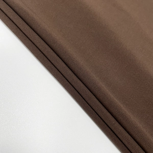 Détail du tissu en maille marron chocolat avec une fine texture côtelée verticale