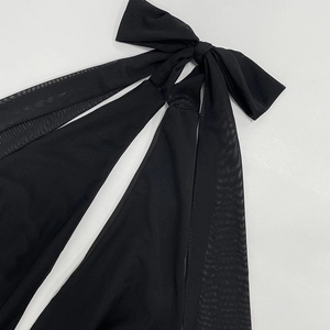 Detail of elegant black mesh bow tie strap on backless bodycon dress shoulder