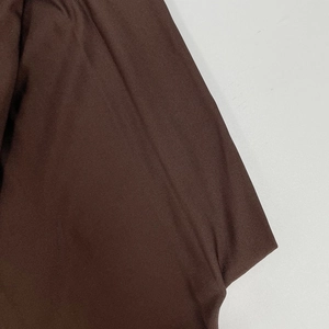 Detailed macro shot of dark brown fine ribbed knit fabric showing texture and elasticity