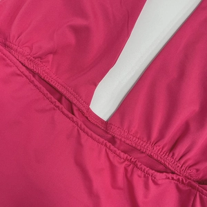 Detailed macro view of magenta halter top showing ruching and cutout detail