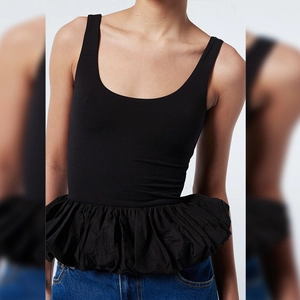 Détail d'un haut noir sans manches à col carré avec une taille à basque et volants élégants