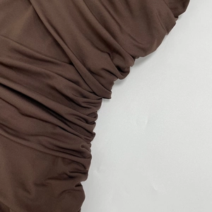 Detail of dark brown ruching texture on elegant slim fit sleeveless knitted dress