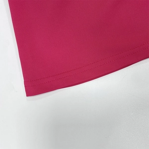 Close-up of rose red halter top hem showing fine knit texture and neat double-needle stitching