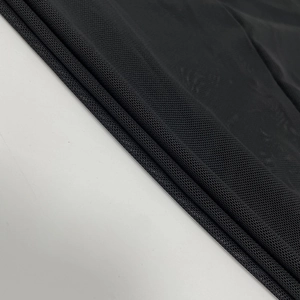 Close-up of black breathable mesh fabric with fine hexagonal texture and high elasticity