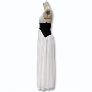 Détail d'une robe longue dos nu avec haut blanc et contraste de couleur noire à la taille
