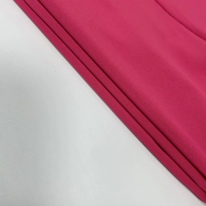 Close-up of the rose red ribbed knit fabric texture on this sexy halter neck top