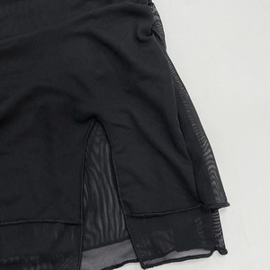 Detail of black double-layered mesh fabric and fine split seam stitching on the dress