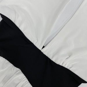 Vue macro détaillée de la couture de taille noire et de la jupe en mesh plissé blanc de la robe