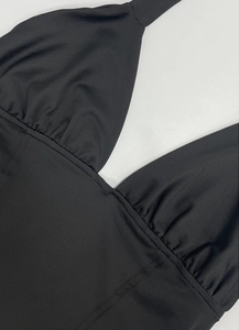 Dettaglio body nero allacciato al collo con scollo a V e design del petto con ruches chic