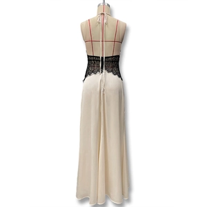 Close-up of elegant cream satin dress with intricate black lace patchwork and backless design