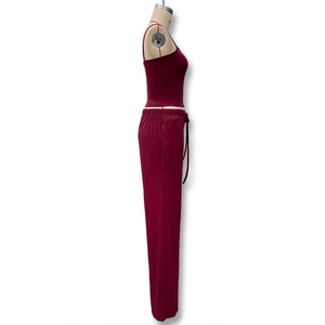 Détail d'un ensemble deux pièces bordeaux avec caraco et pantalon à cordon sur un mannequin