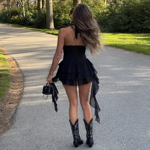 Robe dos nu noire à volants et bottes brodées de style western lors d'une séance en plein air
