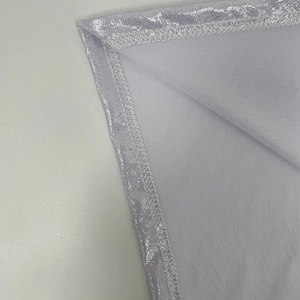 Detail von silbernem Glitzerstoff mit sauberer Overlock-Naht auf dem weißen Innenfutter