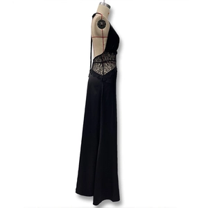 Detail of elegant black satin evening dress featuring intricate floral lace on the waist