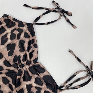 Detailed view of leopard print dress featuring side ruching and delicate tie-up straps