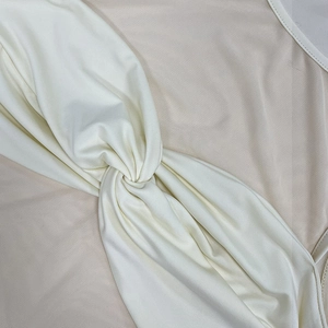 Close-up of elegant mesh splice twist detail on a slim-fit white fish-tail dress