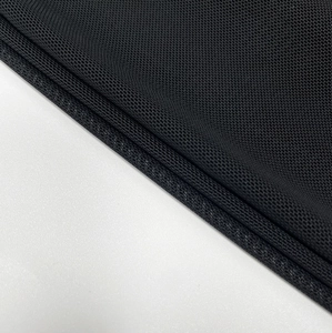 Close-up of black mesh fabric with breathable honeycomb structure and neat edge stitching
