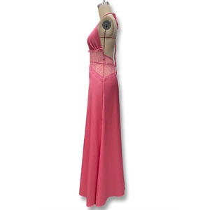 Detail of pink backless satin maxi dress featuring intricate lace waist paneling