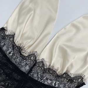 Detail of champagne satin dress featuring exquisite black eyelash lace embroidery edges