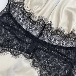 Close-up of elegant eyelash lace stitching on off-white silk satin dress material