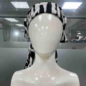 Detail of the black and white zebra pattern turban with elegant draped back and knot design