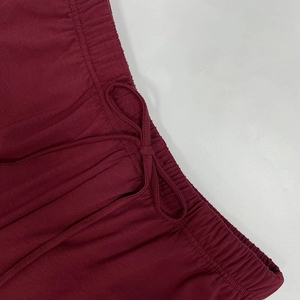 Détail de pantalon bordeaux avec taille élastique et cordon de serrage réglable