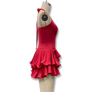 Detail of red halter dress featuring tiered ruffle layers and side button fasteners