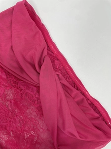 Close-up of rose pink lace floral fabric and sheer mesh details on a summer dress