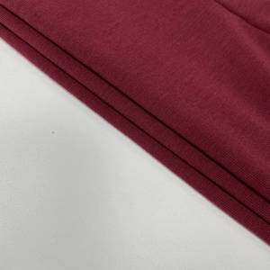 Gros plan détaillé sur la texture du tricot rouge foncé avec couches côtelées et coutures