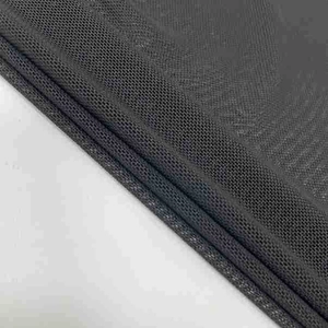 Detailed macro view of black fine mesh fabric texture showing honeycomb knit structure