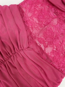 Macro detail of fuchsia pleated mesh and floral lace paneling on the sleeveless dress